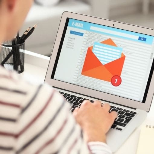 Person using a laptop with an email icon on the screen